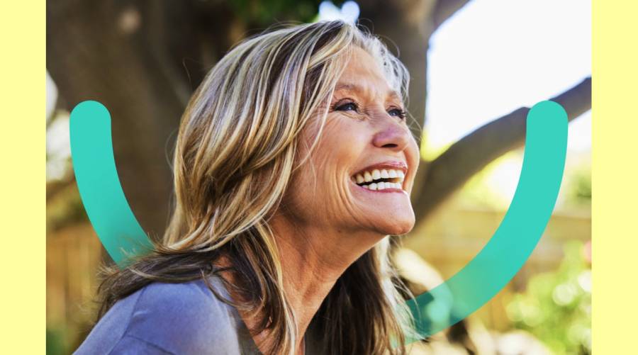 Elderly woman smiling with strong teeth, highlighting the connection between oral health and well-being.