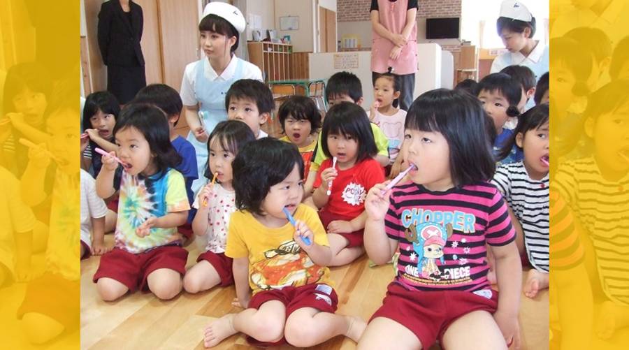 Japanese children brushing teeth at school as part of a national oral health initiative.